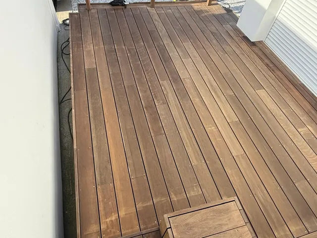 Intervention de nettoyage de terrasse en cours sur un platelage bois dans les Landes